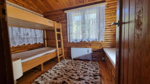 a wooden cabin with a bunk bed and a window at Domek Szumin-Wywłoka in Majdan