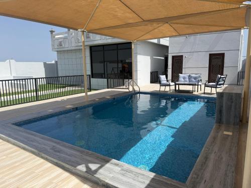 a swimming pool with an umbrella on top of a building at Ras Al Hadd's bounty in Sur