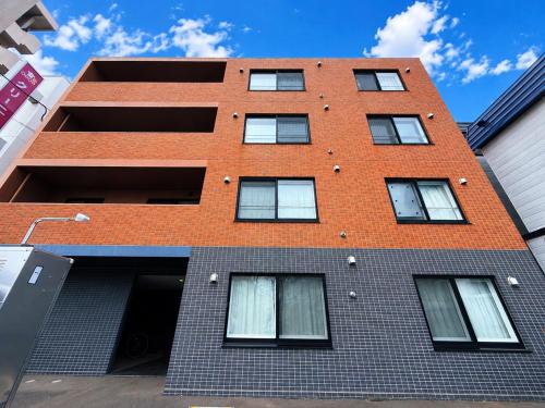 a red brick building with windows on a street at Excel 美園 -FIX HOME- in Sapporo