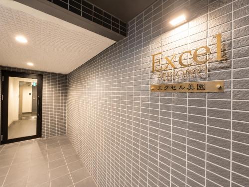a restroom with blue tiled walls and a sign on the wall at Excel 美園 -FIX HOME- in Sapporo