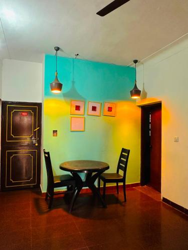 a dining room with a table and two chairs at New Jtr Residency in Ernakulam