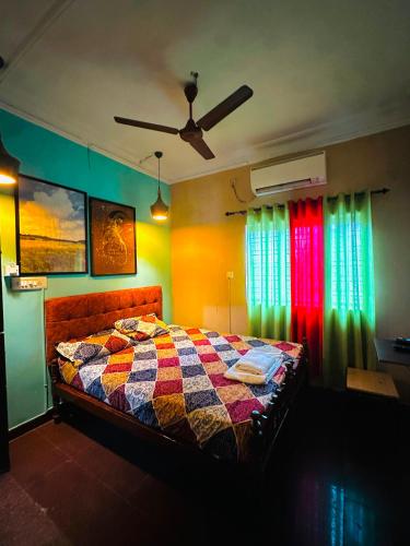 a bedroom with a bed with a colorful quilt at New Jtr Residency in Ernakulam
