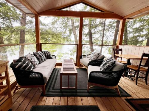 a screened in porch with two couches and a table at Walker Lake Resort in Huntsville
