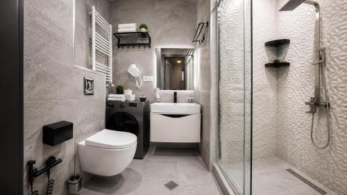 a bathroom with a toilet and a sink and a shower at Gori Palace - Modern Apartments in City Centre in Gori