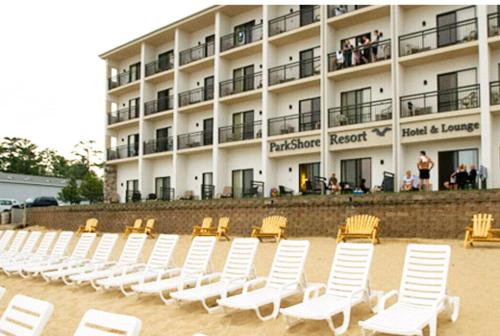 a row of white chairs in front of a building at Parkshore Resort in Traverse City