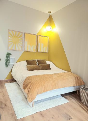 a bedroom with a large bed with a yellow wall at Studio cosy Le3bis proche Cap d'Agde in Bessan