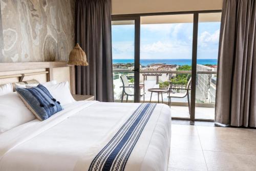 a bedroom with a bed and a view of the ocean at Hotel Indigo Playa del Carmen by IHG in Playa del Carmen