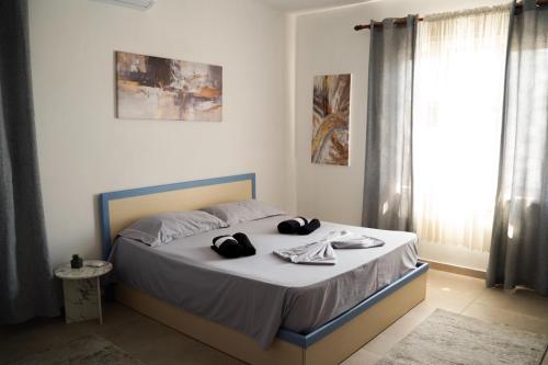 a bedroom with a bed with hats and towels on it at Guest House by Roni in Durrës