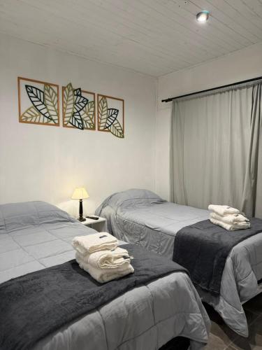 a bedroom with two beds with towels on them at Complejo San Carlos in General Acha