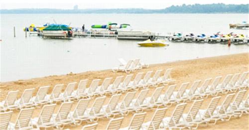 a group of chairs on a beach near the water at Parkshore Resort in Traverse City