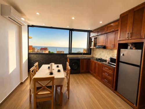 a kitchen with a table and a refrigerator at Belle appart in Aguemoun Taïda