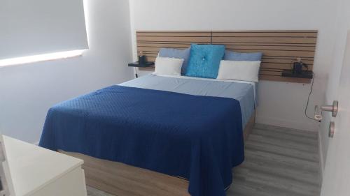 a bedroom with a blue bed with a wooden headboard at Casa Alentejana in Mora