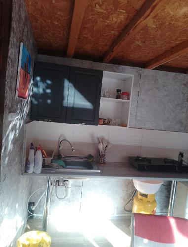 a kitchen with a sink and a flat screen tv at Irina Holiday House in Mangalia