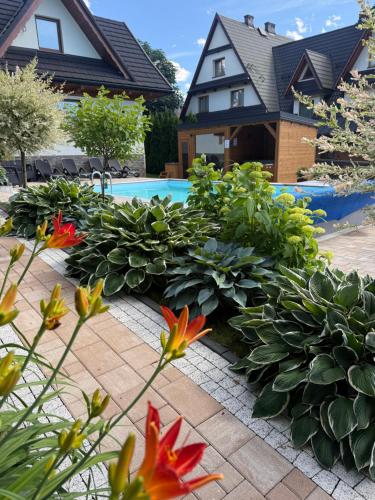 a garden with flowers in front of a house at Domek Góralski U Hanki Domek przy Stoku in Małe Ciche