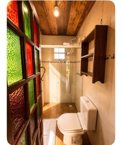 a bathroom with a toilet and stained glass windows at Reserva Natural Aguaraguazu Cânion Guartelá in Tibagi