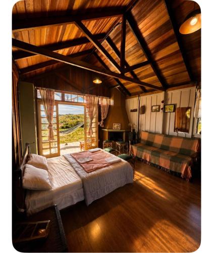 a bedroom with a large bed and a large window at Reserva Natural Aguaraguazu Cânion Guartelá in Tibagi