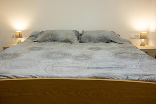 a large bed with two pillows on top of it at Holiday House Štrbački buk in Donji Lapac