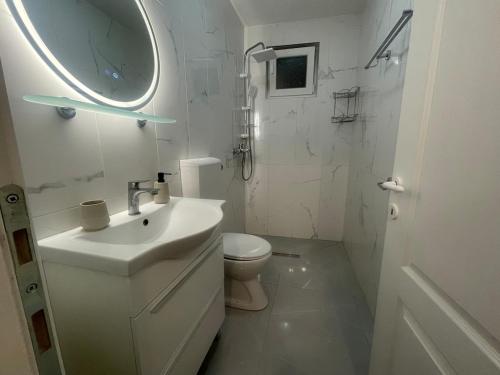 a white bathroom with a sink and a toilet at Hvar-Zarace Ina 2 in Gdinj