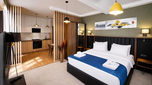 a hotel room with a large bed and a kitchen at Gori Palace - Modern Apartments in City Centre in Gori
