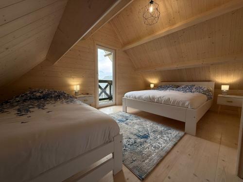 a attic bedroom with two beds and a window at Osada Mielenko in Mielenko