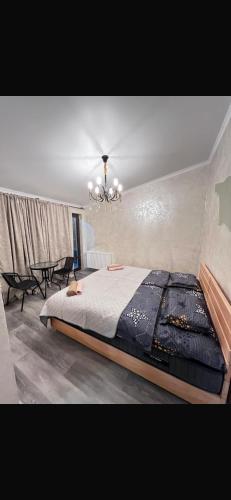 a bedroom with a large bed and a chandelier at NikO's Stay in Mestia