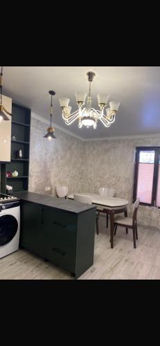 a kitchen with a table and a chandelier at NikO's Stay in Mestia
