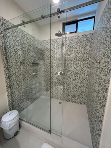 a bathroom with a glass shower with a toilet at Sal y Sol in Quepos