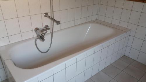 a white bath tub with a shower in a bathroom at Ditzumerhuuske in Ditzum