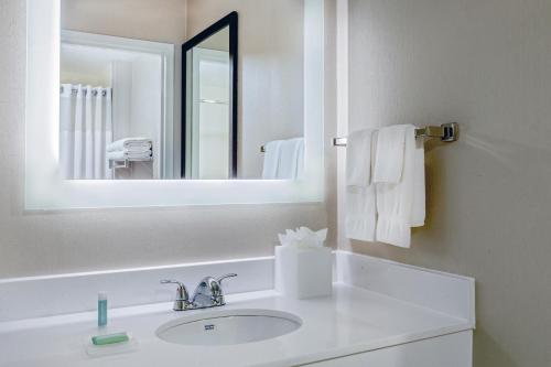 a white bathroom with a sink and a mirror at SpringHill Suites Boston Peabody in Peabody