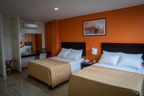 a hotel room with two beds and a desk at ZAMORA EJECUTIVO EXPRESS in Zamora de Hidalgo