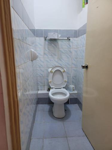 a bathroom with a toilet with the lid up at Greatwall Apartment in Syokimau
