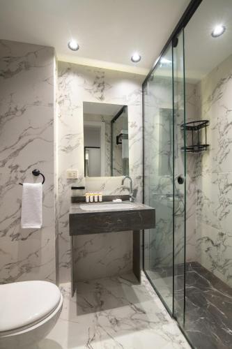 a bathroom with a sink and a toilet and a shower at Santino Boutique Hotel in El Alamein