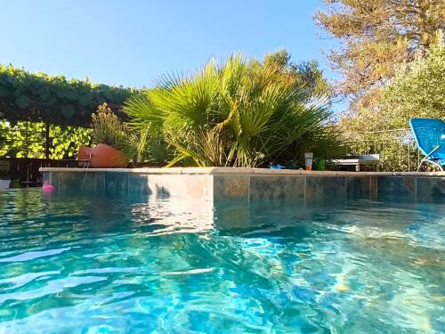 a swimming pool with blue water in a yard at Etage privatif chez Corinne in Russan