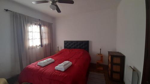 a bedroom with a red bed with two towels on it at Rosibel in Río Ceballos