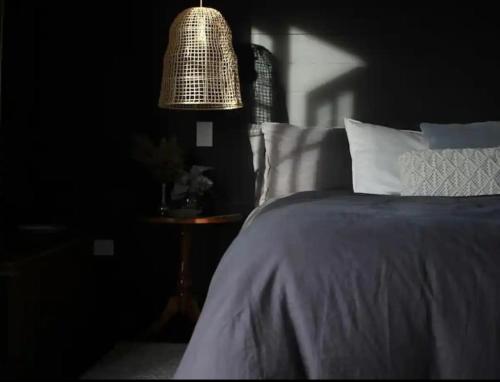 a bedroom with a bed and a table with a lamp at The Milkmans Shack in Dunorlan