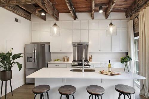 a kitchen with a white counter and some stools at Luxe 8BR CBD Duplex Private Courtyard in New Orleans