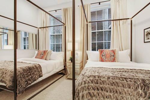a bedroom with two beds and a mirror at Luxe 8BR CBD Duplex Private Courtyard in New Orleans