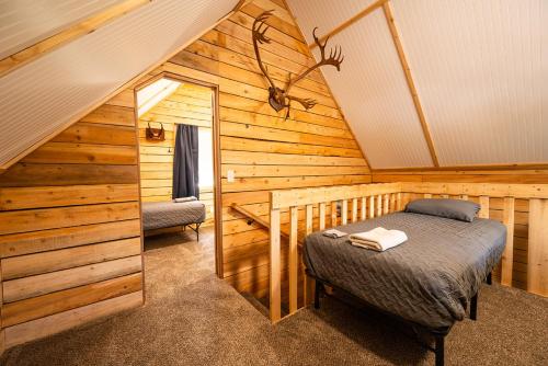 a bedroom with a bed in a wooden cabin at Red Salmon Retreat, Cabin 8 at Lower Kenai Lodge in Kenai
