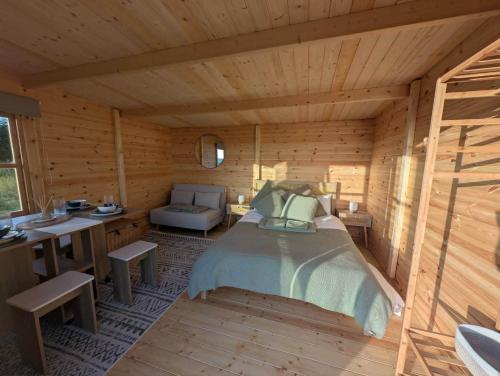 a bedroom of a log cabin with a bed and a desk at Skyline cabin in Bugle