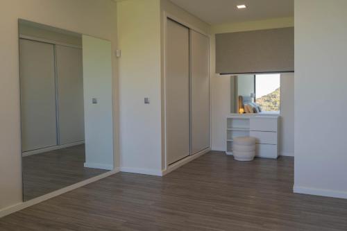 an empty room with white walls and wood floors at Luna Villa in Campanário