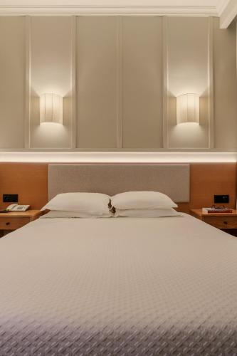 a bedroom with a bed with two lights above it at Cova da Iria Hotel in Fátima
