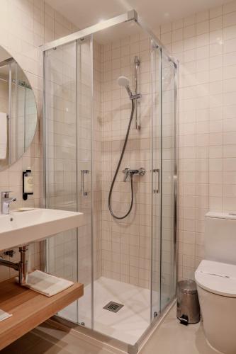 a bathroom with a shower and a toilet and a sink at Cova da Iria Hotel in Fátima