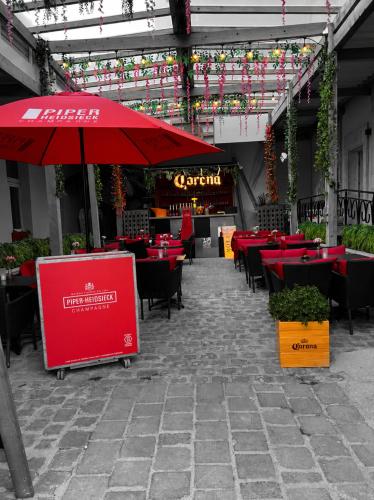 a restaurant with red tables and chairs and an umbrella at Hotel Aux Sacres Reims, Centre Historique in Reims