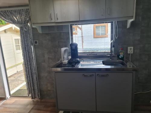 a kitchen with a sink and a window at de Tweelingen - de Tien Heugten in Schoonloo