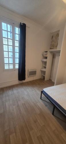 an empty room with a bed and a window at Olti in Avignon