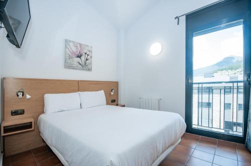 a bedroom with a large bed and a large window at Apartaments VM Molleres in Soldeu