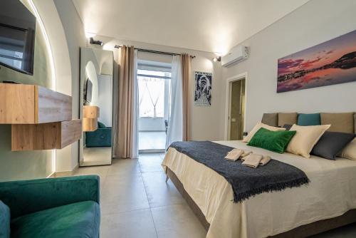 a bedroom with a large bed and a couch at Barrio La Suite del Borgo Bacoli in Bacoli