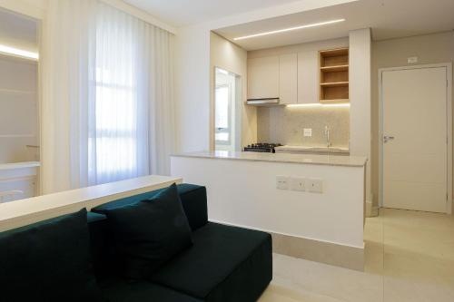 a living room with a couch and a kitchen at Luggo Inter Residence - Região Central BH in Belo Horizonte