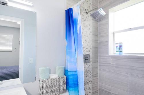 a bathroom with a shower with a blue shower curtain at Mayas Blue Lagoon Luxury Suite #2 in Fort Lauderdale