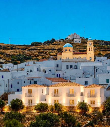a white building with a clock tower on a hill at Dryope Luxury Living in Dhriopís